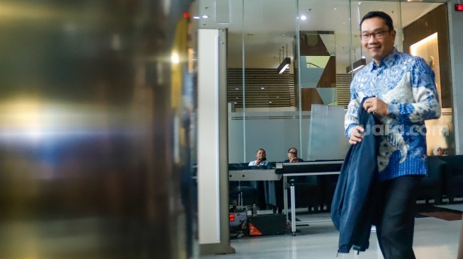 Mantan Gubernur Jawa Barat Ridwan Kamil (tengah) usai menjalani pemeriksaan di Gedung Merah Putih KPK, Jakarta, Selasa (2/12/2025). [Suara.com/Alfian Winanto]