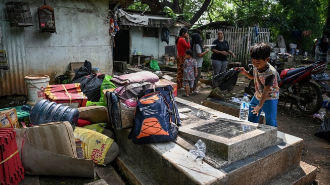 Sejumlah warga berada di depan rumahnya saat proses relokasi di area Tempat Pemakaman Umum (TPU) Menteng Pulo II, Jakarta, Selasa (2/12/2025). [ANTARA FOTO/Fauzan/foc]