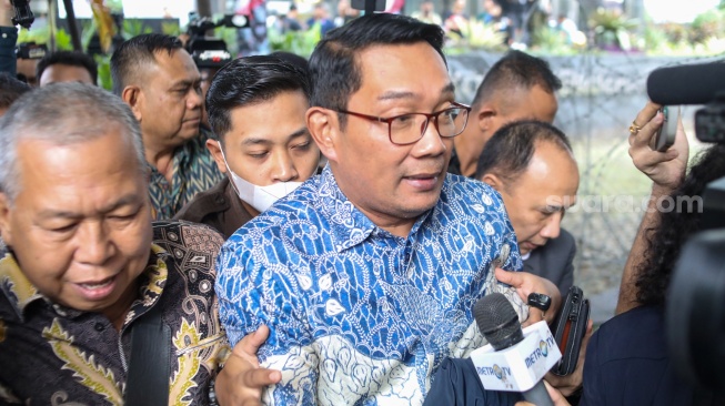 Mantan Gubernur Jawa Barat Ridwan Kamil (tengah) usai menjalani pemeriksaan di Gedung Merah Putih KPK, Jakarta, Selasa (2/12/2025). [Suara.com/Alfian Winanto]