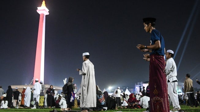 Warga melaksanakan Sholat Isya berjamaah saat mengikuti Reuni 212 di Monas, Jakarta, Selasa (2/12/2025). [ANTARA FOTO/Sulthony Hasanuddin/bar]