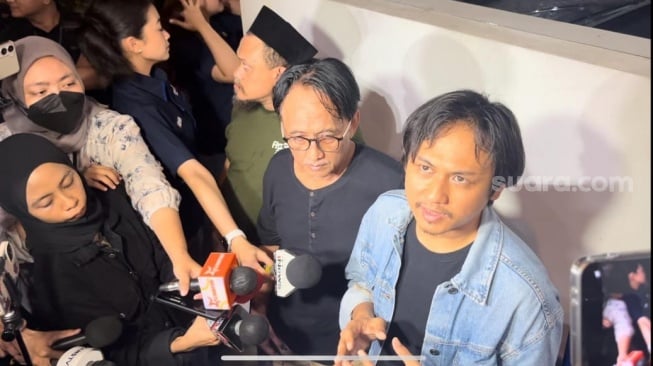 Damar Rizal Marzuki, Anak Epy Kusnandar (jaket denim) dan Deniar Hendarsah, adik Epy Kusnandar (baju hitam) di rumah duka kawasan Jagakarsa, Jakarta Selatan pada Rabu, 3 Desember 2025. [Rena Pangesti/Suara.com]