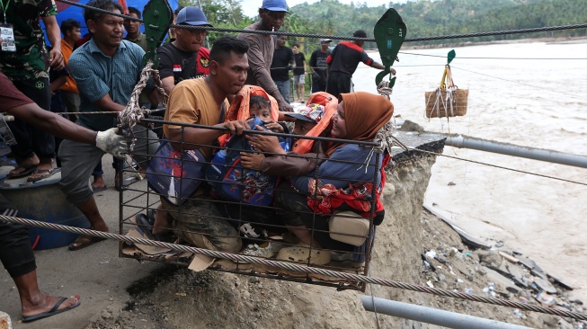Warga menggunakan kabel baja yang untuk menyeberangi Sungai Juli pascaputusnya Jembatan Juli di jalan lintas Bireuen - Takengon, Aceh, Selasa (2/12/2025). [ANTARA FOTO/Irwansyah Putra/bar]