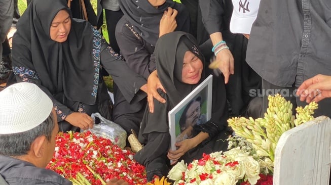 Karina Ranau menangis di pemakaman Epy Kusnandar di TPU Jeruk Purut pada Kamis, 4 Desember 2025. [Suara.com/Tiara Rosana]
