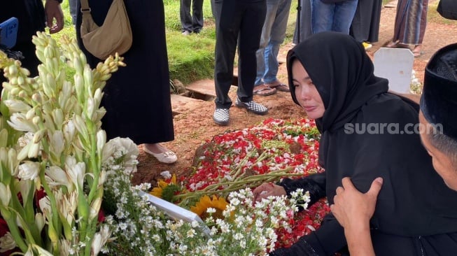 Karina Ranau menangis di pemakaman Epy Kusnandar di TPU Jeruk Purut pada Kamis, 4 Desember 2025. [Suara.com/Tiara Rosana]
