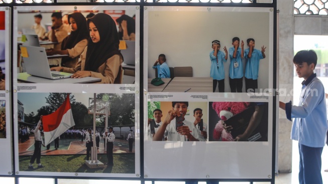 Pengunjung mengamati sejumlah karya yang ditampilkan pada pameran Haluan Merah Putih di selasar Al Fattah, Masjid Istiqlal, Jakarta, Jumat (5/12/2025). [Suara.com/Alfian Winanto]