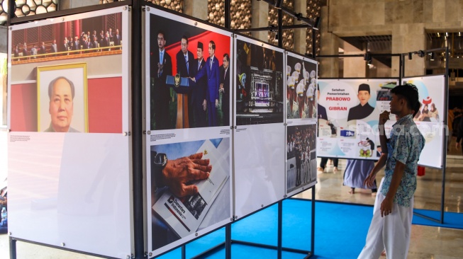 Pengunjung mengamati sejumlah karya yang ditampilkan pada pameran Haluan Merah Putih di selasar Al Fattah, Masjid Istiqlal, Jakarta, Jumat (5/12/2025). [Suara.com/Alfian Winanto]