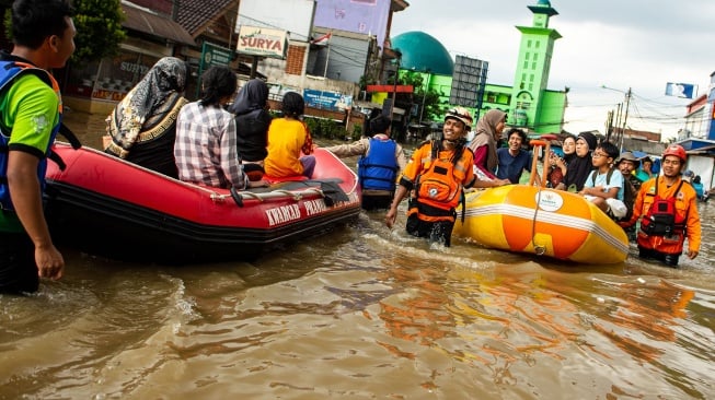 Petugas SAR gabungan membawa warga menggunakan perahu saat melintasi banjir di Jalan Raya Dayeuhkolot, Kabupaten Bandung, Jawa Barat, Sabtu (6/12/2025). [ANTARA FOTO/Novrian Arbi/foc]