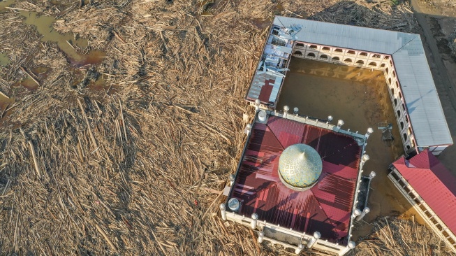 Foto udara menampilkan tumpukan kayu-kayu memenuhi area Pondok Pesantren Darul Mukhlishin pascabanjir bandang di Desa Tanjung Karang, Karang Baru, Kabupaten Aceh Tamiang, Aceh, Jumat (5/12/2025). [ANTARA FOTO/Erlangga Bregas Prakoso/app/foc]