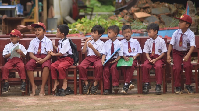 Sejumlah siswa duduk menunggu kedatangan meja dan kursi untuk ujian di SDN 05 Batang Anai, Padang Pariaman, Sumatera Barat, Senin (8/12/2025). [ANTARA FOTO/Iggoy el Fitra/foc]
