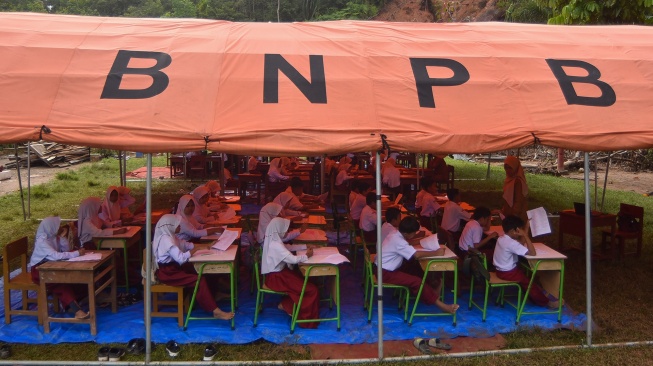 Sejumlah siswa mengikuti ujian di bawah tenda, di SDN 05 Batang Anai, Padang Pariaman, Sumatera Barat, Senin (8/12/2025). [ANTARA FOTO/Iggoy el Fitra/foc]