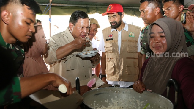 Presiden Prabowo Subianto (ketiga kiri) didampingi Gubernur Aceh Muzakir Manaf (tengah) mencicipi makanan yang dimasak di dapur umum posko pengungsian bencana alam Desa Belee Panah, Bireuen, Aceh, Minggu (7/12/2025). [ANTARA FOTO/Irwansyah Putra/nz]