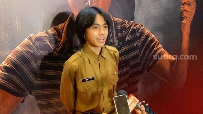 Quentin Stanislavski, anak bungsu Epy Kusnandar mengenakan kostum ayahnya di film Qorin 2 saat ditemui di kawasan Kuningan, Jakarta Selatan pada Senin, 8 Desember 2025. [Suara.com/Tiara Rosana]
