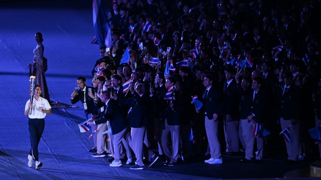 Atlet Taekwondo Thailand Panipak Wongpattanakit (kiri) berlari membawa obor SEA Games saat upacara Pembukaan SEA Games 2025 di Stadion Rajamangala, Bangkok, Thailand, Selasa (9/12/2025). [ANTARA FOTO/Nova Wahyudi/sgd/foc]