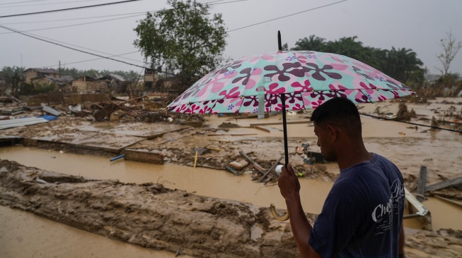 Warga berjalan di desa yang luluh lantak pascabanjir di Desa Bundar, Karang Baru, Kabupaten Aceh Tamiang, Aceh, Selasa (9/12/2025). [ANTARA FOTO/Erlangga Bregas Prakoso/mrh/foc]