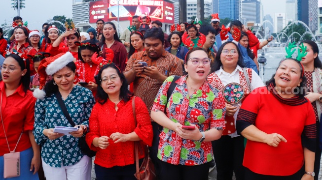 Umat Kristiani bernyanyi saat acara Christmas Carol Colossal di Bundaran HI, Jakarta, Kamis (11/12/2025). [Suara.com/Alfian Winanto]

