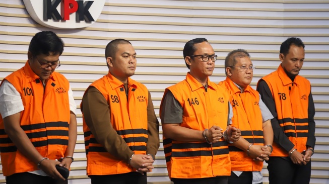 Bupati Lampung Tengah Ardito Wijaya (tengah) bersama Anggota DPRD Lampung Tengah Riki Hendra Saputra, Adik Bupati Lampung Tengah Ardito Wijaya, Ranu Hari Prasetyo, Plt. Kepala Badan Pendapatan Daerah Lampung Tengah Anton Wibowo dan Pihak Swasta Mohamad Lukman Sjamsuri mengenakan rompi tahanan usai menjalani pemeriksaan di Gedung Merah Putih KPK, Jakarta, Kamis (11/12/2025). [Suara.com/Alfian Winanto]
