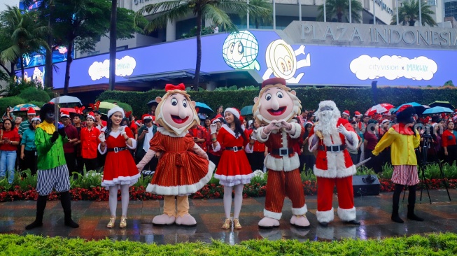 Umat Kristiani bernyanyi saat acara Christmas Carol Colossal di Bundaran HI, Jakarta, Kamis (11/12/2025). [Suara.com/Alfian Winanto]

