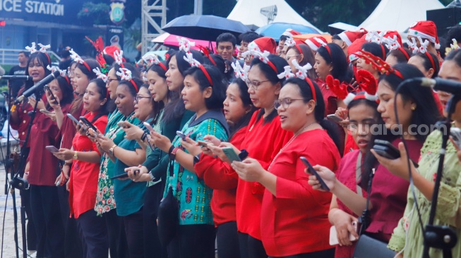 Umat Kristiani bernyanyi saat acara Christmas Carol Colossal di Bundaran HI, Jakarta, Kamis (11/12/2025). [Suara.com/Alfian Winanto]
