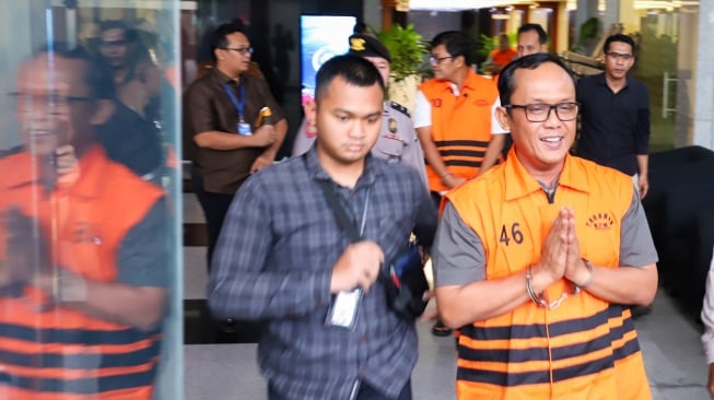 Bupati Lampung Tengah Ardito Wijaya (kanan) berjalan menuju mobil tahanan usai menjalani pemeriksaan di Gedung Merah Putih KPK, Jakarta, Kamis (11/12/2025). [Suara.com/Alfian Winanto]