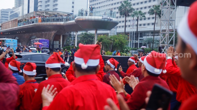 Umat Kristiani bernyanyi saat acara Christmas Carol Colossal di Bundaran HI, Jakarta, Kamis (11/12/2025). [Suara.com/Alfian Winanto]
