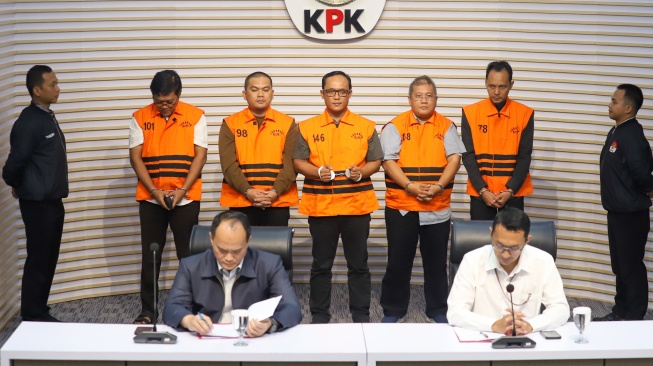 Bupati Lampung Tengah Ardito Wijaya (tengah) bersama Anggota DPRD Lampung Tengah Riki Hendra Saputra, Adik Bupati Lampung Tengah Ardito Wijaya, Ranu Hari Prasetyo, Plt. Kepala Badan Pendapatan Daerah Lampung Tengah Anton Wibowo dan Pihak Swasta Mohamad Lukman Sjamsuri mengenakan rompi tahanan usai menjalani pemeriksaan di Gedung Merah Putih KPK, Jakarta, Kamis (11/12/2025). [Suara.com/Alfian Winanto]
