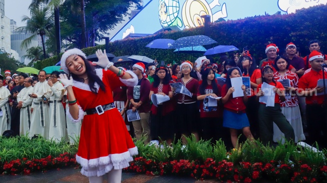 Umat Kristiani bernyanyi saat acara Christmas Carol Colossal di Bundaran HI, Jakarta, Kamis (11/12/2025). [Suara.com/Alfian Winanto]
