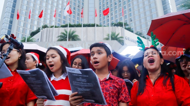 Umat Kristiani bernyanyi saat acara Christmas Carol Colossal di Bundaran HI, Jakarta, Kamis (11/12/2025). [Suara.com/Alfian Winanto]
