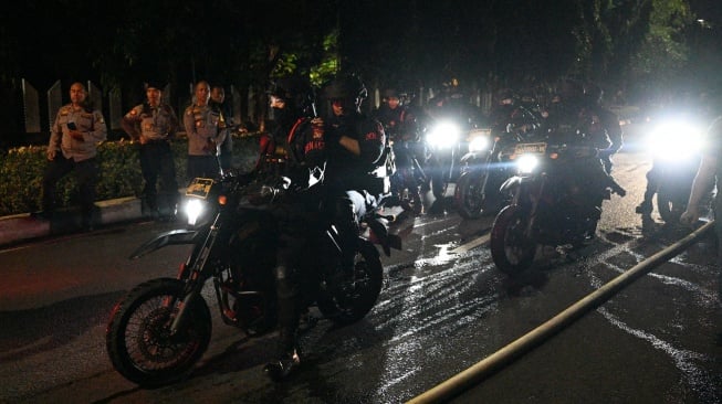 Warga mengambil gambar mobil yang dibakar massa saat kericuhan di kawasan Kalibata, Jakarta, Kamis (11/12/2025). [ANTARA FOTO/Fauzan/rwa]