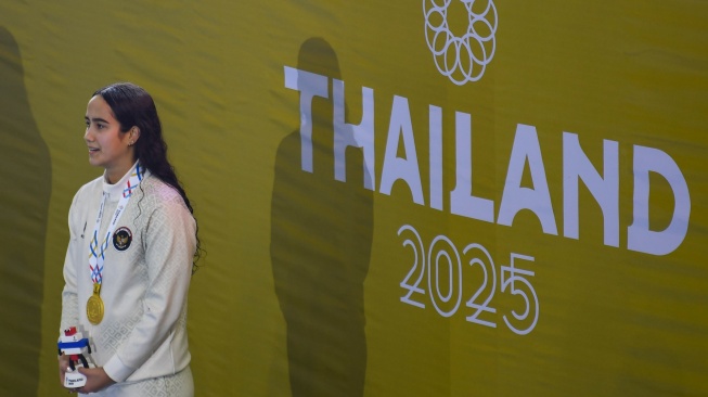 Perenang Indonesia Masniari Wolf mengikuti upacara penghormatan pemenang setelah meraih medali emas nomor 50 meter gaya punggung putri SEA Games 2025 di SAT Swimming Pool, Bang Kapi, Bangkok, Kamis (11/12/2025). [ANTARA FOTO/Muhammad Ramdan/app/nym]
