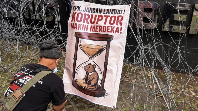 Warga Kabupaten Pati yang tergabung dalam Aliansi Masyarakat Pati Bersatu memasang poster saat melakukan unjuk rasa di depan Gedung Merah Putih KPK, Jakarta, Senin (15/12/2025). [ANTARA FOTO/Indrianto Eko Suwarso/tom]