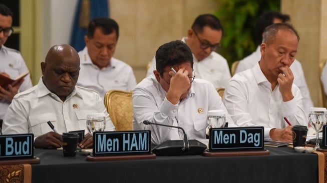 Menteri Perdagangan Budi Santoso (tengah), Menteri Perindustrian Agus Gumiwang Kartasasmita (kanan) dan Menteri Hak Asasi Manusia (HAM) Natalius Pigai (kiri) menyimak instruksi dari Presiden Prabowo Subianto saat Sidang Kabinet Paripurna di Istana Negara, Jakarta, Senin (15/12/2025). [ANTARA FOTO/Galih Pradipta/YU]