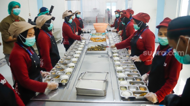 Petugas menyiapkan menu Makan Bergizi Gratis (MBG) yang dikelola Jimmy Hantu di SPPG Mutiara Keraton Solo, Tamansari, Bogor, Selasa (16/12/2025). [Suara.com/Alfian Winanto]