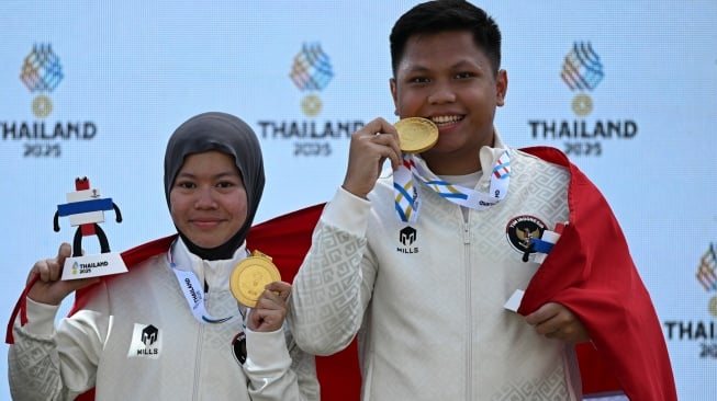 Dua penembak Indonesia Muhammad Iqbal Raia prabowo (kanan) dan Arista Perdana Putri Darmoyo (kiri) berpose dengan medali usai upacara penghargaan pemenang (UPP) final nomor 10 meter Air Rifle tim campuran cabang menembak SEA Games 2025 di Photharam Shooting Range, Bangkok, Thailand, Senin (15/12/2025). [ANTARA FOTO/Nova Wahyudi/tom]