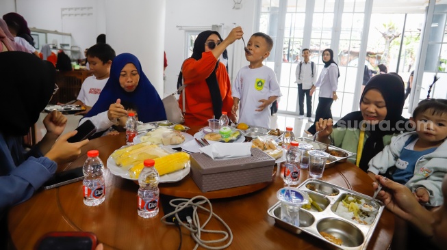 Sejumlah orang tua memberikan Makan Bergizi Gratis (MBG) kepada anak-anak dalam kegiatan Cegah Stunting (Centing) yang digelar di Jimmy Hantu Foundation, Kecamatan Tamansari, Kabupaten Bogor, Jawa Barat, Selasa (16/12/2025). [Suara.com/Alfian Winanto]