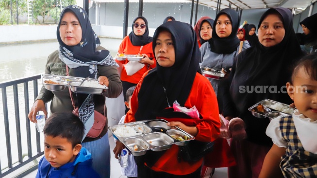 Sejumlah orang tua memberikan Makan Bergizi Gratis (MBG) kepada anak-anak dalam kegiatan Cegah Stunting (Centing) yang digelar di Jimmy Hantu Foundation, Kecamatan Tamansari, Kabupaten Bogor, Jawa Barat, Selasa (16/12/2025). [Suara.com/Alfian Winanto]