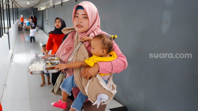 Sejumlah orang tua memberikan Makan Bergizi Gratis (MBG) kepada anak-anak dalam kegiatan Cegah Stunting (Centing) yang digelar di Jimmy Hantu Foundation, Kecamatan Tamansari, Kabupaten Bogor, Jawa Barat, Selasa (16/12/2025). [Suara.com/Alfian Winanto]