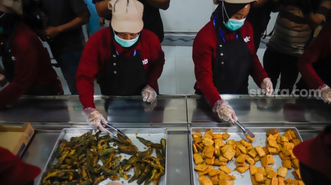 Petugas menyiapkan menu Makan Bergizi Gratis (MBG) yang dikelola Jimmy Hantu di SPPG Mutiara Keraton Solo, Tamansari, Bogor, Selasa (16/12/2025). [Suara.com/Alfian Winanto]