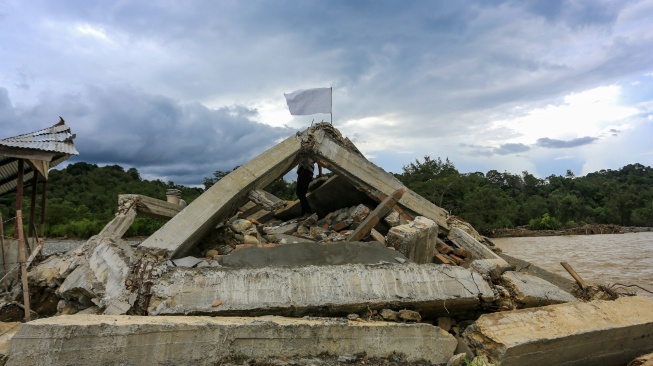 Warga memasangkan bendera putih di depan rumahnya yang rusak pasca bencana hidrometeorologi di Desa Jambak, Kecamatan Pante Ceureumen, Aceh Barat, Aceh, Rabu (17/12/2025). [ANTARA FOTO/Syifa Yulinnas/foc]