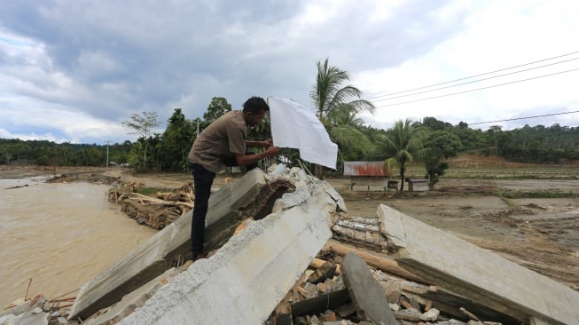 Warga memasangkan bendera putih di depan rumahnya yang rusak pasca bencana hidrometeorologi di Desa Jambak, Kecamatan Pante Ceureumen, Aceh Barat, Aceh, Rabu (17/12/2025). [ANTARA FOTO/Syifa Yulinnas/foc]