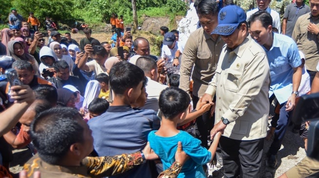 Presiden Prabowo Subianto menyapa masyarakat saat tiba di Nagari Kayu Tanam, Padang Pariaman, Sumatera Barat, Kamis (18/12/2025). [ANTARA FOTO/Iggoy el Fitra/tom]