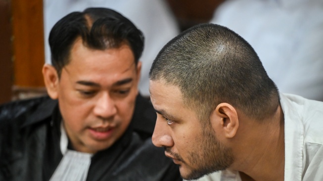 Terdakwa kasus peredaran narkotika di dalam Rutan Salemba Ammar Zoni (kanan) berbincang dengan kuasa hukumnya saat mengikuti sidang lanjutan di Pengadilan Negeri Jakarta Pusat, Kamis (18/12/2025). [ANTARA FOTO/Rivan Awal Lingga/tom]