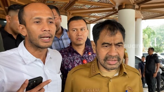 Gubernur Aceh, Muzakir Manaf alias Mualem (kanan) didampingi Juru Bicara Pemerintah Aceh, Muhammad MTA (kiri) saat dijumpai di depan Gedung Kantor Gubernur, Kota Banda Aceh. [Suara.com/Iskandar]