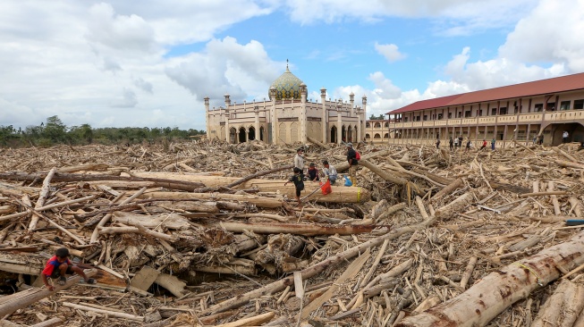 Petugas Kementerian Kehutanan dan Dinas Kehutanan Provinsi Aceh mengambil sampel kayu gelondongan yang terbawa arus luapan Sungai Tamiang, di area pasantren Islam Terpadu Darul Mukhlishin, Desa Tanjung Karang, Aceh Tamiang, Aceh, Jumat (19/12/2025). [ANTARA FOTO/Irwansyah Putra/nym]