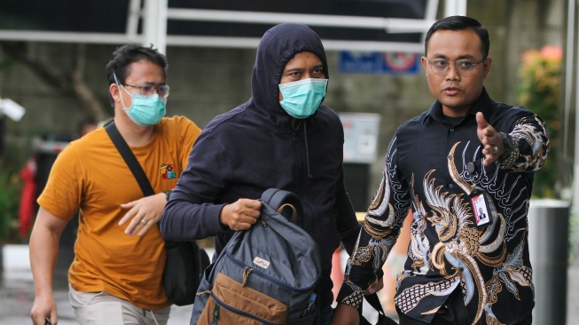 Kepala Seksi Intelijen Kejaksaan Negeri (Kejari) Hulu Sungai Utara (HSU) Asis Budianto (tengah) dikawal petugas saat tiba di Gedung Merah Putih KPK usai terjaring operasi tangkap tangan (OTT), Jakarta, Jumat (19/12/2025). [ANTARA FOTO/Zaigham Priatna/IES/sgd]