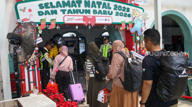 Penumpang menunggu kedatangan kereta api di Stasiun Pasar Senen, Jakarta Pusat, Senin (22/12/2025). [Suara.com/Alfian Winanto]