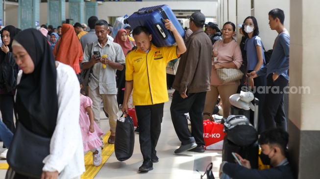 Penumpang menunggu kedatangan kereta api di Stasiun Pasar Senen, Jakarta Pusat, Senin (22/12/2025). [Suara.com/Alfian Winanto]