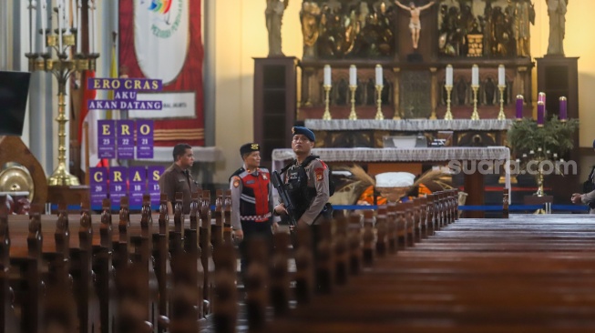 Petugas memeriksa keamanan di Gereja Katedral, Jakarta, Selasa (23/12/2025). [Suara.com/Alfian Winanto]
