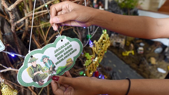 Umat Kristiani merapikan diorama tempat kelahiran Yesus di Gereja Katolik Santo Thomas, Desa Pandan Makmur, Tanjung Jabung Timur, Jambi, Selasa (23/12/2025). [ANTARA FOTO/Wahdi Septiawan/bar]