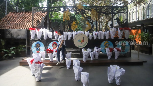 Petugas memasang dekorasi di Gereja Katedral, Jakarta, Selasa (23/12/2025). [Suara.com/Alfian Winanto]