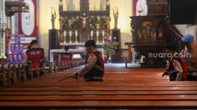 Petugas memeriksa keamanan di Gereja Katedral, Jakarta, Selasa (23/12/2025). [Suara.com/Alfian Winanto]
